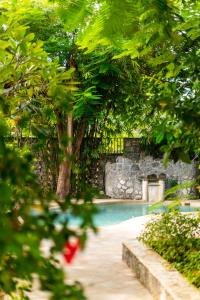 a swimming pool with a stone wall and trees at Mvuvi Boutique Resort in Kiwengwa