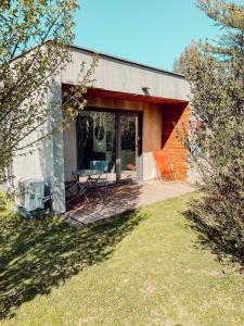 a small house with a porch and a patio at Le Clos Vernay in Nivolas-Vermelle