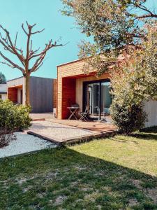 een huis met een patio en een boom bij Le Clos Vernay in Nivolas-Vermelle