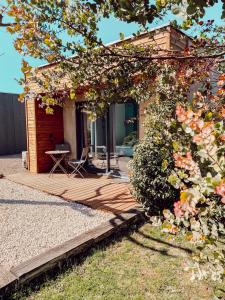 ein Haus mit einer Holzterrasse mit einem Tisch darauf in der Unterkunft Le Clos Vernay in Nivolas-Vermelle