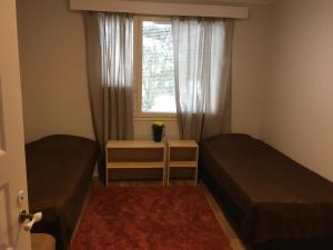 a small bedroom with two beds and a window at Apartment with garden and teracce- Free parking in Oulu