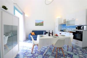 a kitchen and living room with a table and chairs at Mary's Apartments - De Vivo Realty Massa Lubrense in Massa Lubrense
