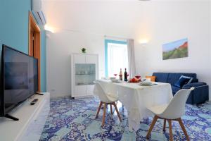 a living room with a white table and chairs at Mary's Apartments - De Vivo Realty Massa Lubrense in Massa Lubrense