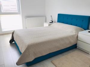 - un lit avec une tête de lit bleue dans une chambre dans l'établissement Piatra Craiului Residence Zărnești, à Zărneşti