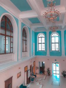 a large room with blue walls and windows and a chandelier at President-hotel Tavrida in Yalta