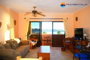 a living room with a couch and a table and a tv at Marina Pinacate A-521 in Puerto Peñasco