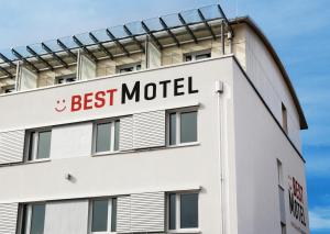 ein weißes Gebäude mit einem Schild, das das beste Motel liest in der Unterkunft Best Motel in Vilsbiburg