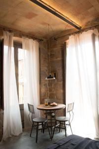 a table and chairs in a room with white curtains at Casa Boutique nº 24 in Cardona