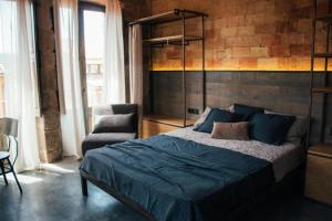 a bedroom with a large bed and a chair at Casa Boutique nº 24 in Cardona