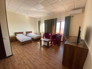 Habitación con 1 dormitorio con 2 camas y escritorio. en Uzumfermer Hotel & Winery, en Tashkent