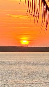 a sunset over the water with the sun in the sky at Ocean Tally in Upper Bogue