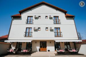 锡比乌拉瑞兹邓塔旅馆的一座白色的大建筑,前面有椅子