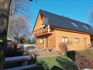 a large wooden house with a black roof at Apartamenty Pod Lipą in Lutowiska