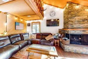 a living room with a leather couch and a fireplace at The Sleepy Hollow in Shaver Lake