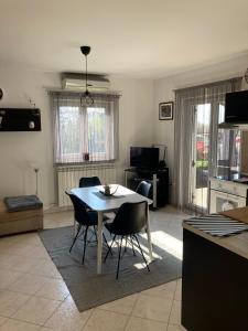 a kitchen and dining room with a table and chairs at Apartman VICINIM family friendly in Višnjan