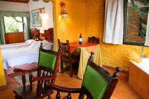 a room with a table and chairs and a bedroom at Hotel Casablanca Natural Spa in Paipa