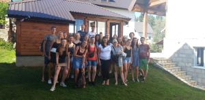 a group of people posing for a picture in front of a cabin at Hostel Highlander in Žabljak
