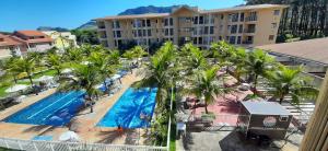 an aerial view of a resort pool with palm trees at Loft Sahy - Condado Aldeia dos Reis in Mangaratiba
