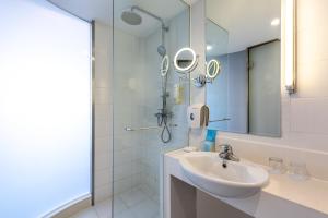 a white bathroom with a sink and a shower at LeafIN Hotel Beijing Wangjing SOHO in Beijing +19 photos