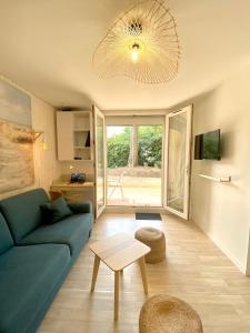 uma sala de estar com um sofá azul e uma mesa em Appartement t2 , bord de mer, accès direct plage em Saint-Nazaire