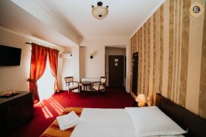 a hotel room with a bed and a table at La Rezidenta in Sibiu
