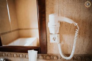 un teléfono en la pared en un baño con bañera en La Rezidenta, en Sibiu