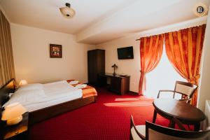 Habitación de hotel con cama, escritorio y ventana en La Rezidenta en Sibiu