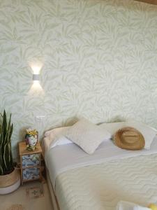 a bedroom with a bed and a wall with a pineapple wallpaper at Made in Sicily Santa Tecla in Acireale