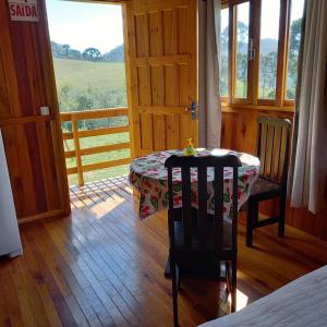 a room with a table and chairs and a window at Chalés Vista Bonita in Urubici