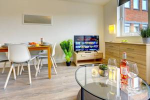a living room with a glass table and a television at Modern & Stylish 2BR Apartment - Queens House in Coventry