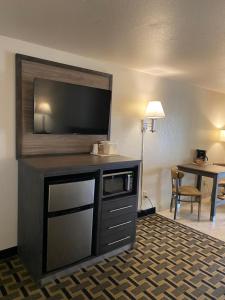 a hotel room with a flat screen tv on top of a cabinet at Motel In The Pines in Munds Park