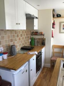 a kitchen with white cabinets and a wooden counter top at Conference View Guest House in Harrogate