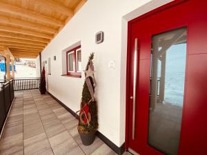 eine rote Tür mit einem Weihnachtsbaum auf dem Flur in der Unterkunft Ferienwohnungen Reinbacher - Primps in Schladming