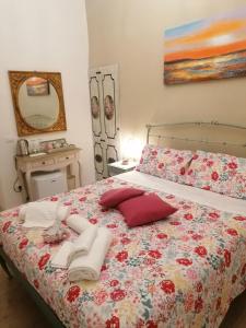a bedroom with a bed with towels and a mirror at Affittacamere Shabby old town in Florence