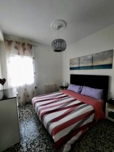 バレンシアにあるPiso en la playaのベッドルーム1室(大型ベッド1台、ストライプ毛布付)