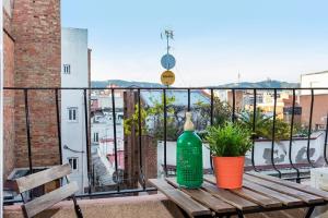 a green bottle sitting on a wooden table on a balcony at Pleasant Studio with Balcony Close to Camp Nou in Hospitalet de Llobregat