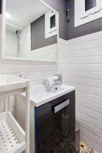 a white bathroom with a sink and a mirror at Pleasant Studio with Balcony Close to Camp Nou in Hospitalet de Llobregat