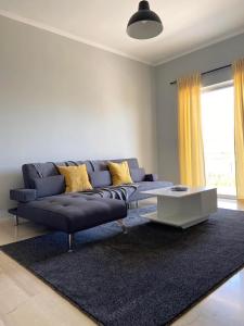 a living room with a blue couch and a table at Aussie Apartments in Sikéa