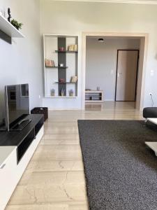 a large living room with a television and a couch at Aussie Apartments in Sikéa