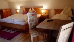 a bedroom with a bed and a desk and a table at Untermühlbauer Fam. Schreder in Saalfelden am Steinernen Meer