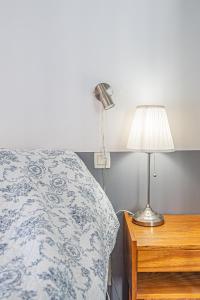 a bedroom with a bed and a table with a lamp at La Roubine, Velleron in Velleron