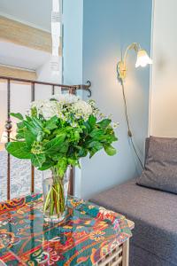 un jarrón de flores en una mesa junto a un sofá en La Roubine, Velleron, en Velleron