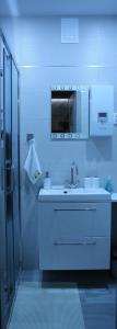 a white bathroom with a sink and a shower at Apartament Dla Dwojga in Ustrzyki Dolne
