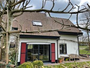 a house with red and white doors and a roof at No Tempo in Knesselare