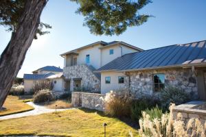 dom z dachem łupkowym i kamienną ścianą w obiekcie WorldMark Hunt – Stablewood Springs Resort w mieście Hunt