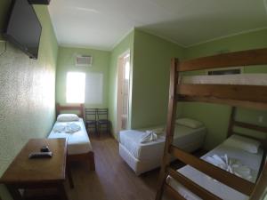 a small room with two bunk beds and a table at Hotel Paris in Jundiaí