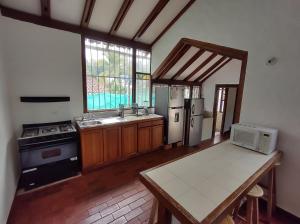 a kitchen with a table and a stove and refrigerator at CASA QUINTA BENDITO PARAÍSO in Melgar