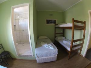 a room with two bunk beds and a shower at Hotel Paris in Jundiaí