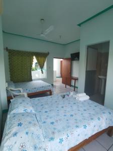 a bedroom with a large bed with a blue comforter at Hotel Gamito in Puerto Escondido