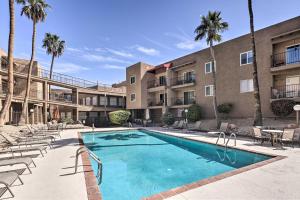 a swimming pool in front of a building with palm trees at Condo with Balcony - Walk to Lake, Dining, and Shops! in Lake Havasu City